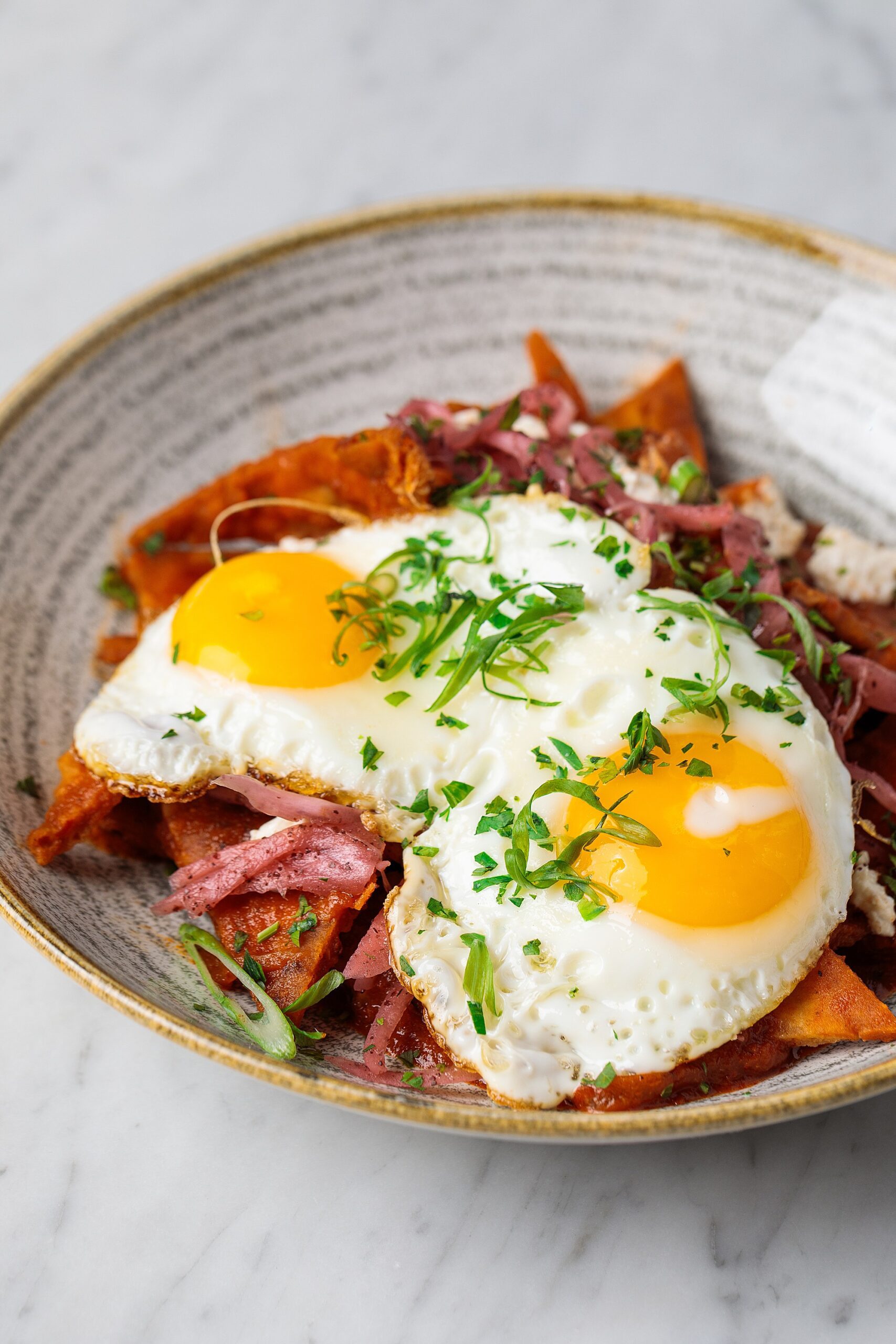 eggs over pitaquiles in a ceramic custom bowl