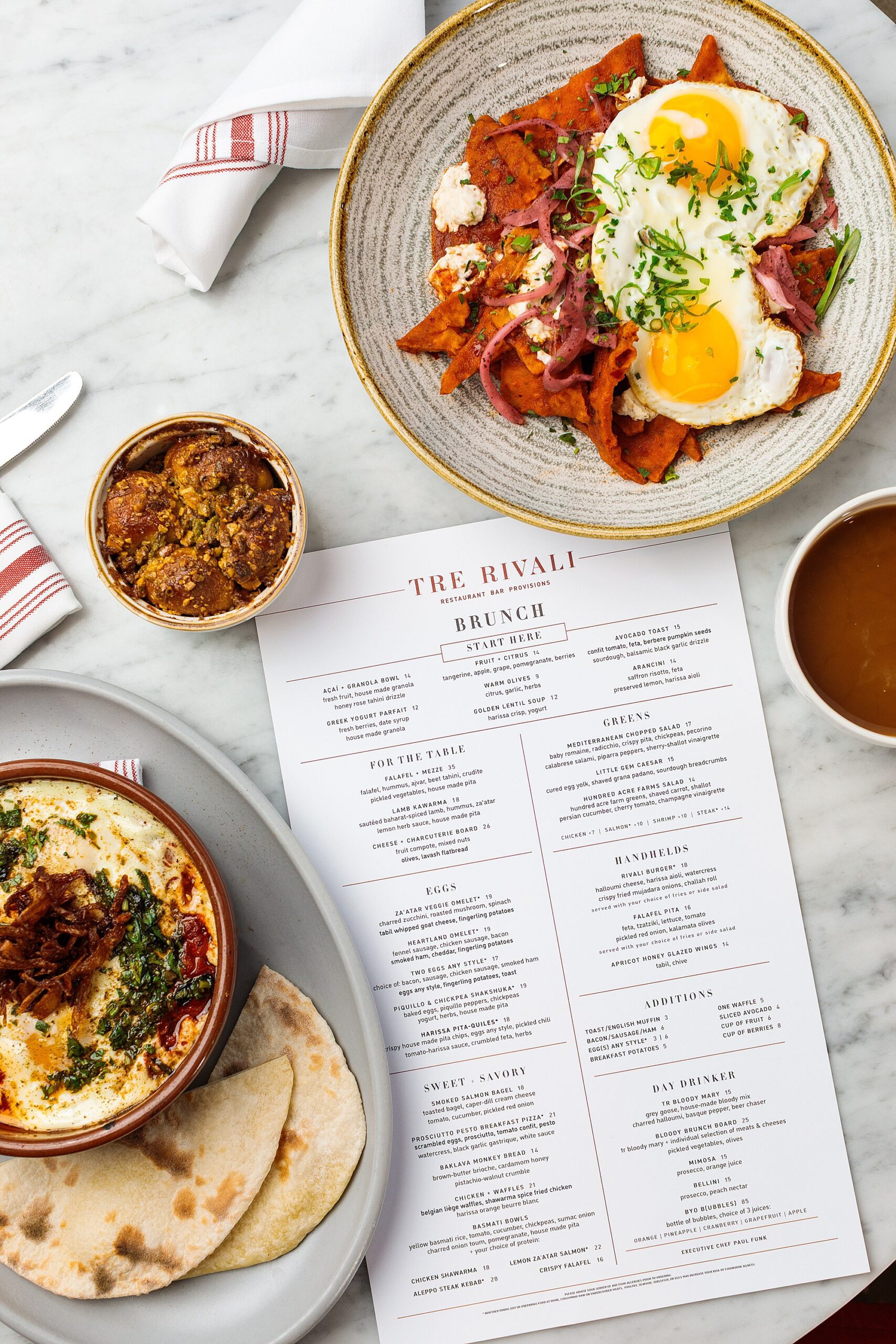 brunch food with eggs and monkeybread and menu on a marble tabletop
