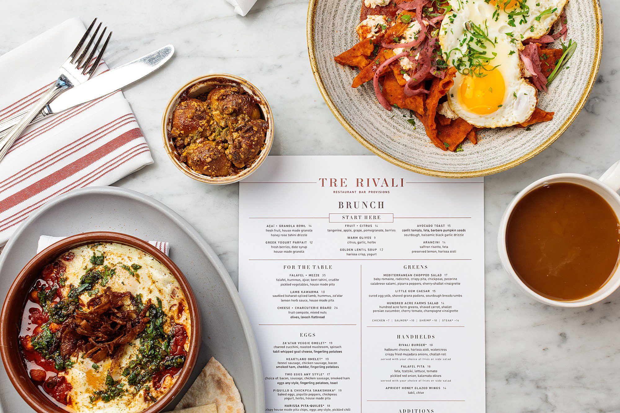 brunch food with eggs and monkeybread and menu on a marble tabletop