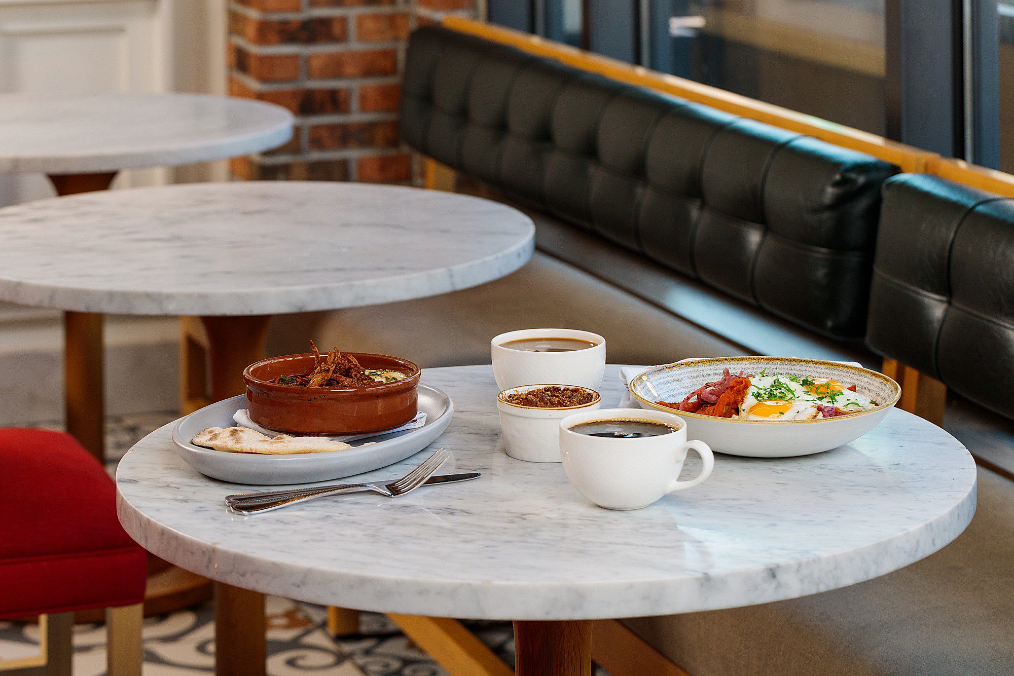brunch table set up on a round marble tabletop in a pretty boutique hotel