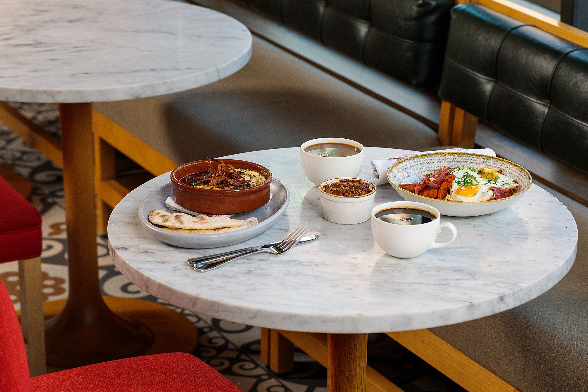 brunch table set up on a round marble tabletop in a pretty boutique hotel