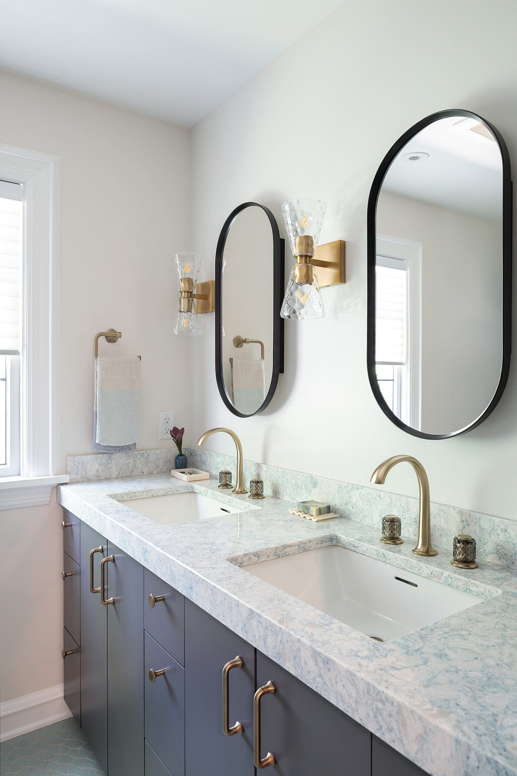 modern bathroom design with gray cabinets and quartz granite countertops and brass finishes and a double sink