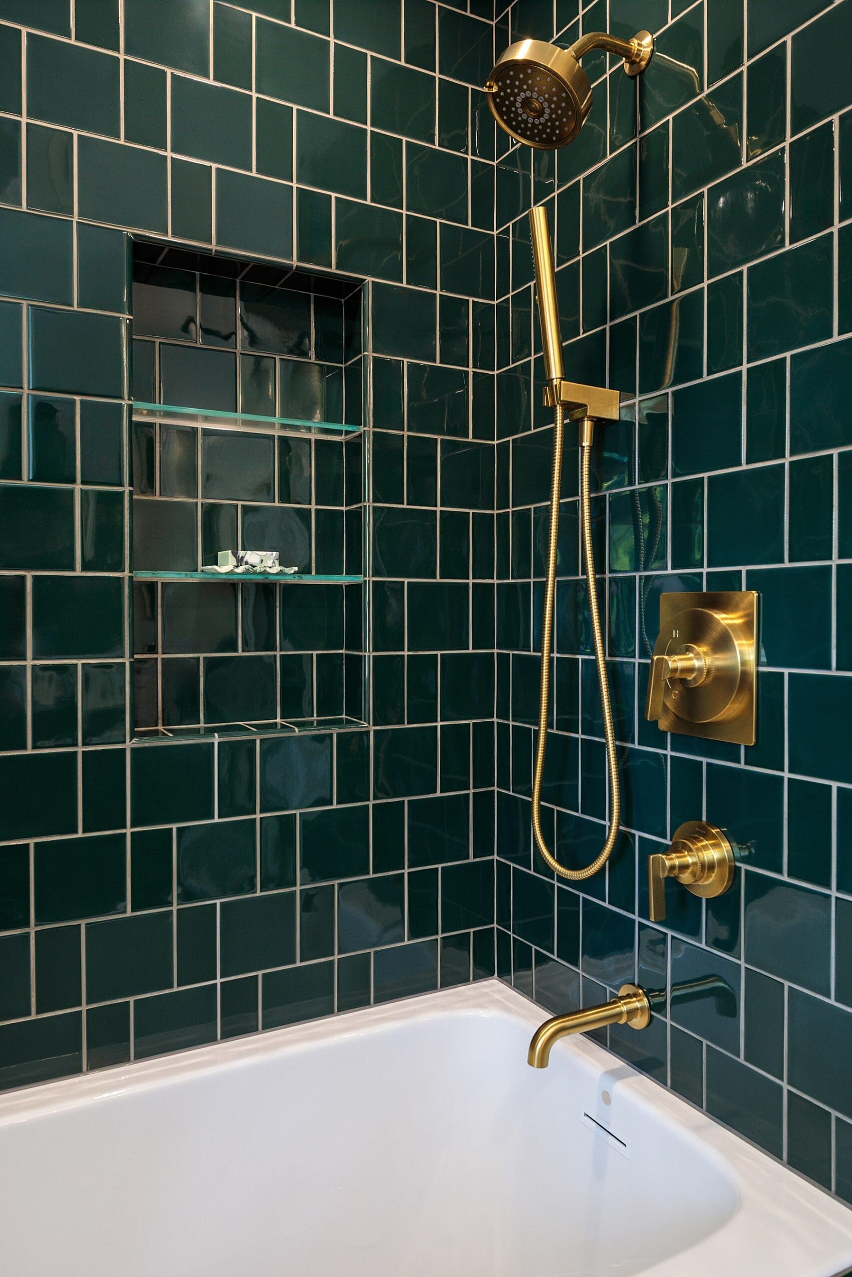 modern bathtub surround design with emerald green tile and brass hardware